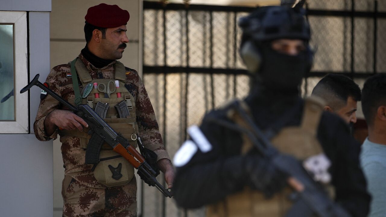 A paramilitary of the Hashed al-shaabi (Popular Mobilisation) forces stands guard during the funeral of a comrade, who died in American air strikes targeting Iran-backed groups the day before, at the Hashed al-shaabi forces' headquarters in Baghdad on January 25, 2024. 